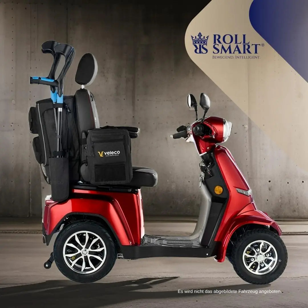 Roter roll smart elektrorollstuhl mit schwarzem sitz und reisetasche für große abenteuer mit silbernen leichtmetallrädern
